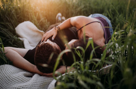 Couple lying in a field Petersfield Beach engagement