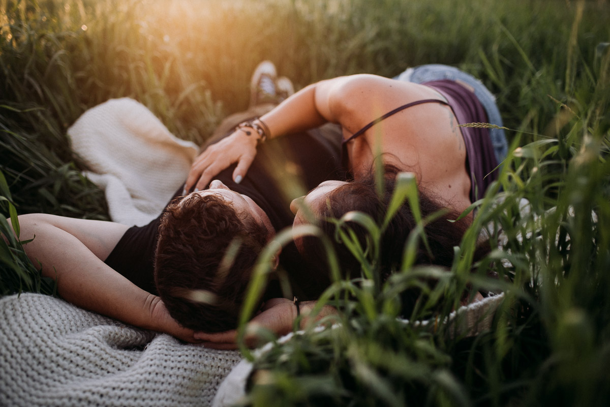 Couple lying in a field Petersfield Beach engagement