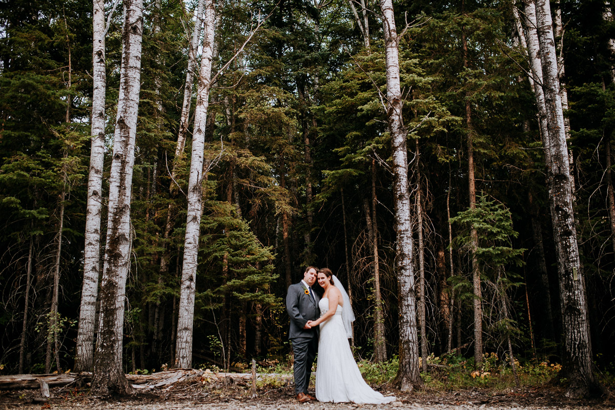 Bride and groom standing in a forest in Clear Lake Manitoba