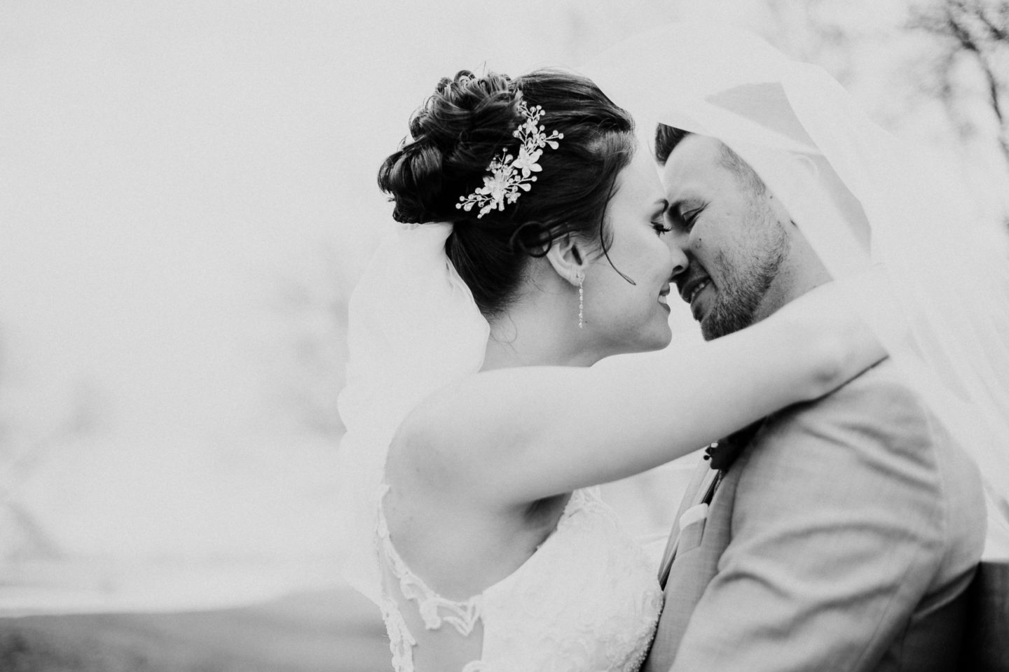 Bride and groom kissing under veil at Ashgrove Acres Manitoba