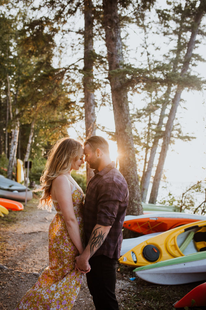 engaged couple near colourful kayaks Riding Mountain National Park