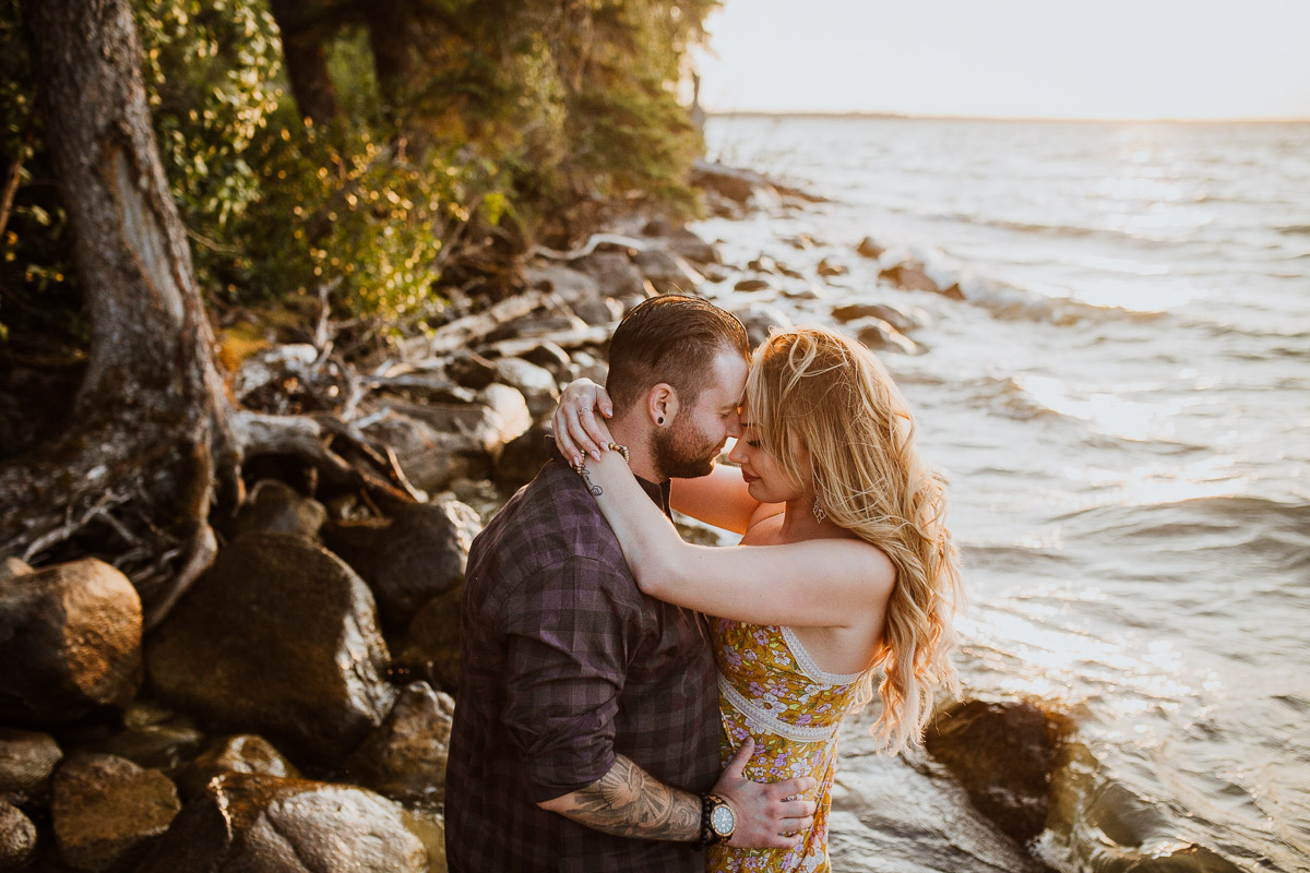 engaged couple hugging in lake at Riding Mountain National Park